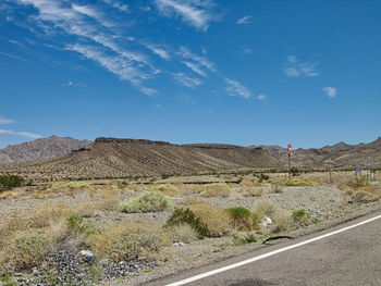 Scenic view of road by land against blue sky