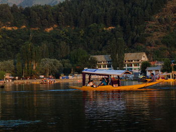 Boat sailing on river by trees