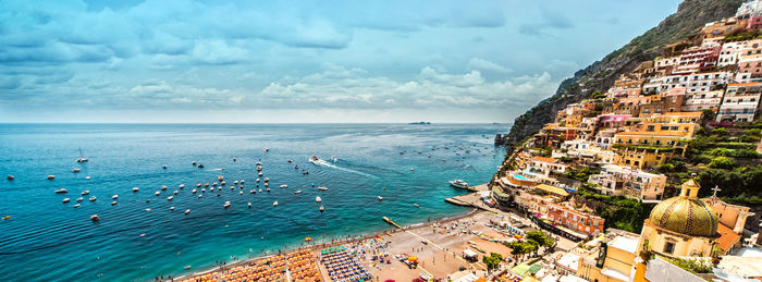 High angle view of townscape by sea against sky