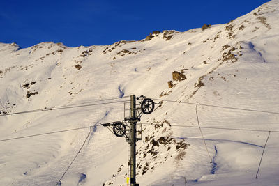 Snow covered mountain against blue sky