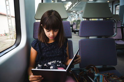 Young woman using mobile phone while sitting in bus