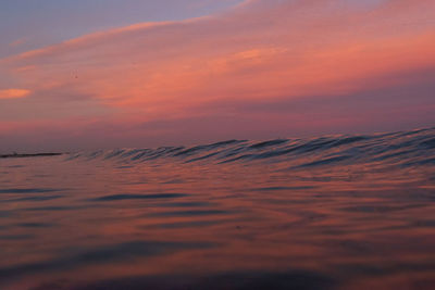 Scenic view of sea against dramatic sky during sunset