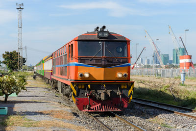 The diesel electric locomotive of the commuter train is arriving at the old urban station.