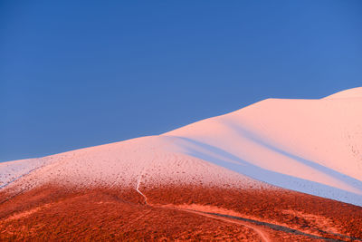 Scenic view of desert against clear blue sky