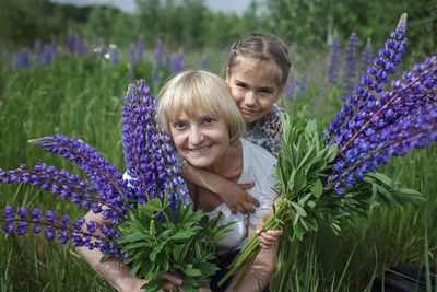 Portrait of young woman standing amidst plants