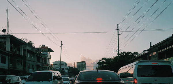 Cars on street amidst buildings against clear sky