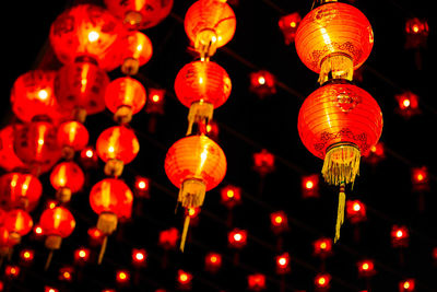 Low angle view of illuminated lanterns hanging at night