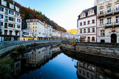 Arch bridge over canal amidst buildings in city