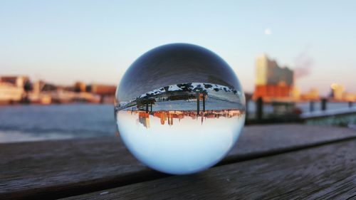 Close-up of illuminated crystal ball on table against sky