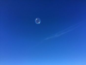 Low angle view of moon against blue sky