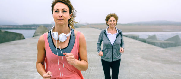 Portrait of smiling woman standing against water