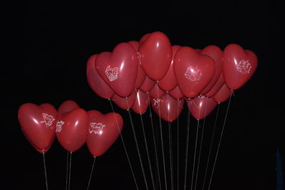 Close-up of heart shape balloons against black background