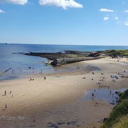 People at beach against blue sky