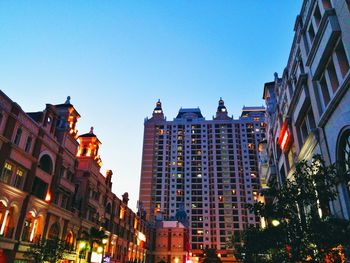 Low angle view of buildings against clear blue sky