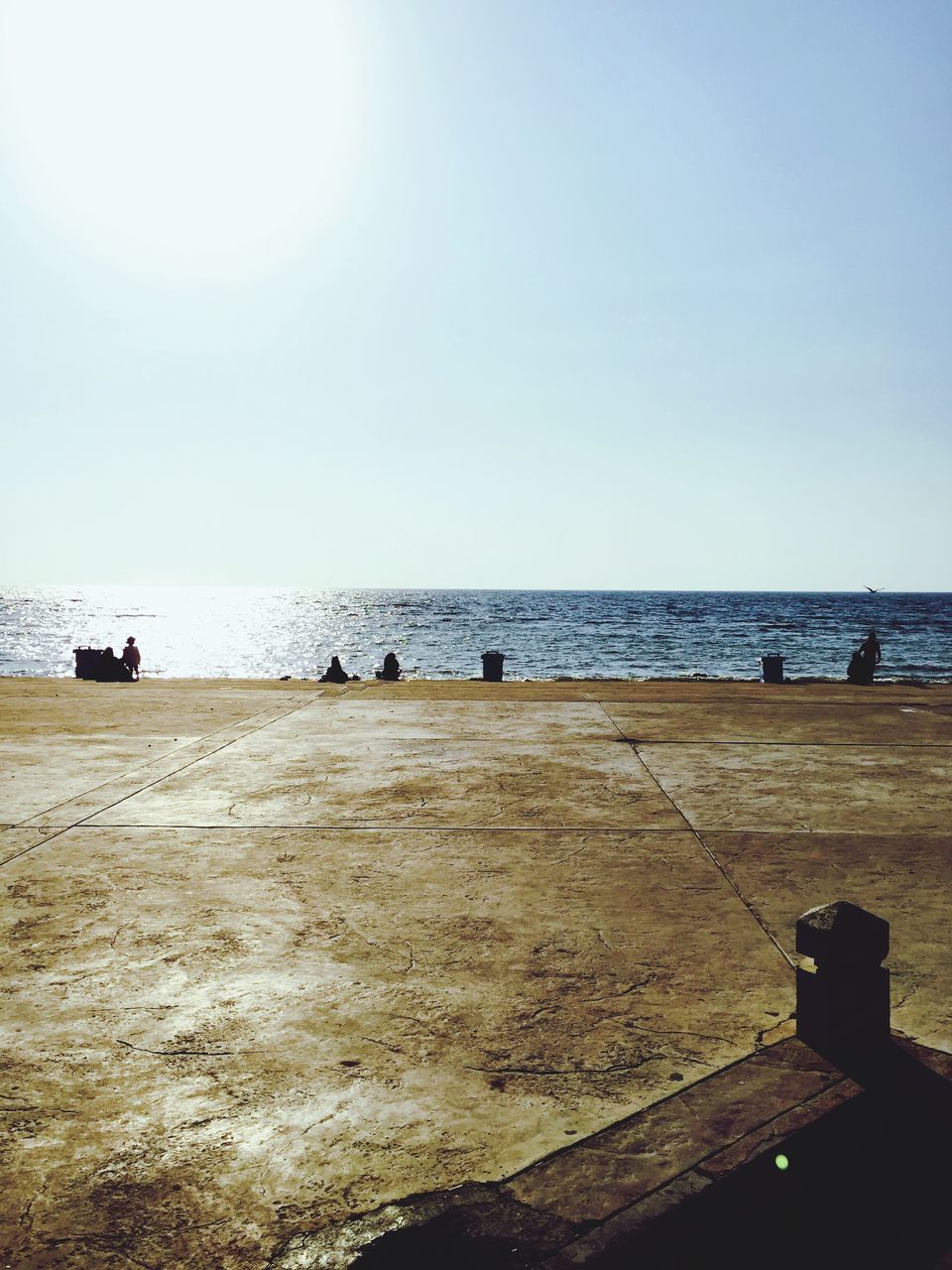 sea, water, horizon over water, beach, clear sky, copy space, tranquil scene, scenics, shore, tranquility, sand, incidental people, beauty in nature, nature, sunlight, blue, sky, men, leisure activity