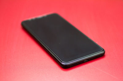 Close-up of smart phone over red background