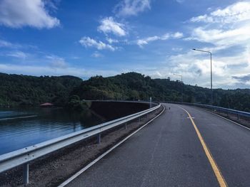 Empty road against cloudy sky