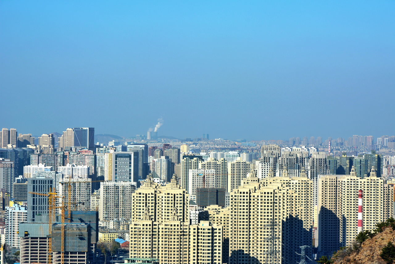 building exterior, cityscape, city, architecture, clear sky, built structure, copy space, skyscraper, crowded, blue, tall - high, residential district, tower, modern, high angle view, office building, urban skyline, residential building, city life, residential structure