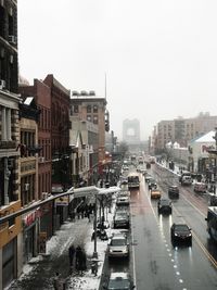 Vehicles on road in city against clear sky