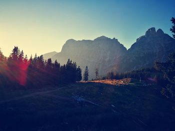 Mountains and field against sky during sunset