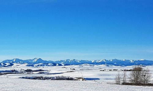 Scenic view of frozen landscape against clear blue sky