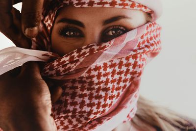 Close-up portrait of a young woman covering face