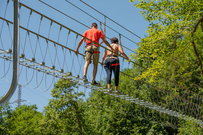 Low angle view of people walking on footbridge