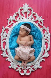 Directly above shot of newborn baby sleeping on patterned bed