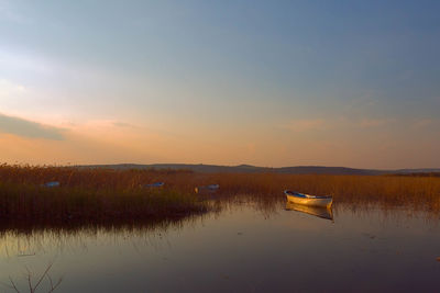 Boats in lake at sunset