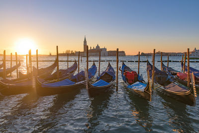 View of boats in canal at sunset