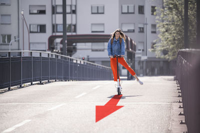 Full length of woman standing on road in city