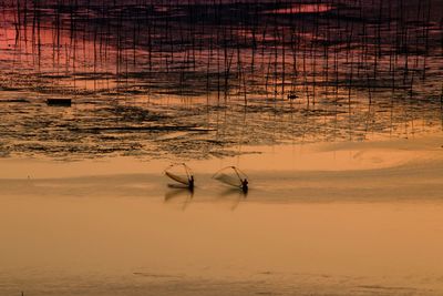 View of fishing net at beach during sunset