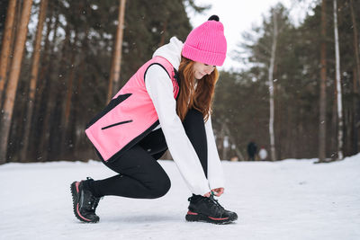 Rear view of woman standing on snow covered field