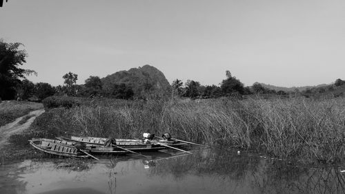 Boats moored on river against clear sky