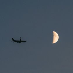 Low angle view of airplane flying against clear sky