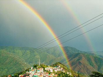 Rainbow over mountain against sky