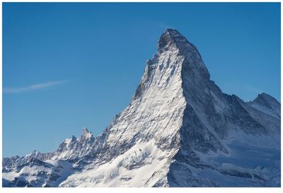 Scenic view of snowcapped mountains against clear blue sky