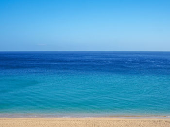 Scenic view of sea against clear blue sky