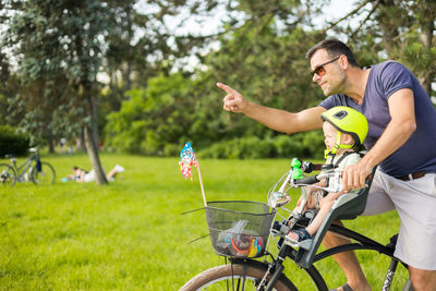 Side view of man riding bicycle on field