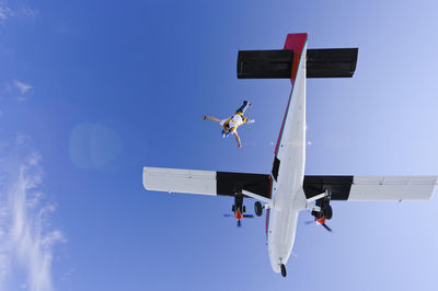 Low angle view of airplane against blue sky