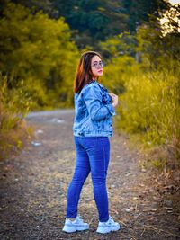 Portrait of young woman standing on road