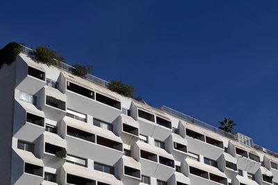 Low angle view of residential building against clear blue sky