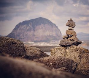 Stack of pebbles on mountain against sky