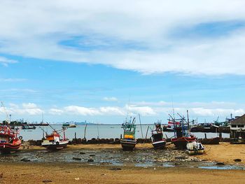 Boats moored at harbor against sky