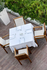 High angle view of chairs arranged by table at yard