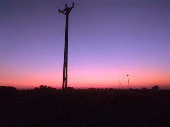 Low angle view of silhouette plants on field against sky at sunset