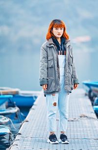 Full length portrait of young woman standing in winter