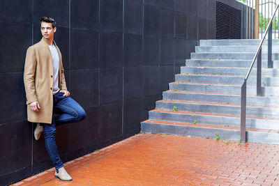 Full length of young man standing on staircase