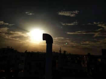 Silhouette buildings against sky during sunset in city