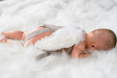 High angle view of toddler boy wearing angel costume on rug